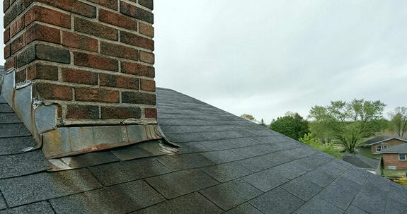 Decayed flashing tracking rust at a chimney's base