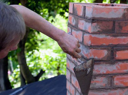 Trowel making a pass along raked joint lines